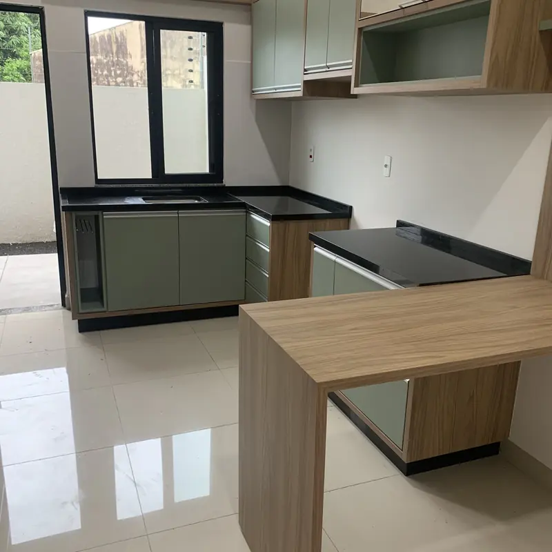 Cozinha com bancada escura e marcenaria verde