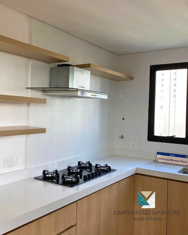 Cozinha com bancada clara e marcenaria em madeira